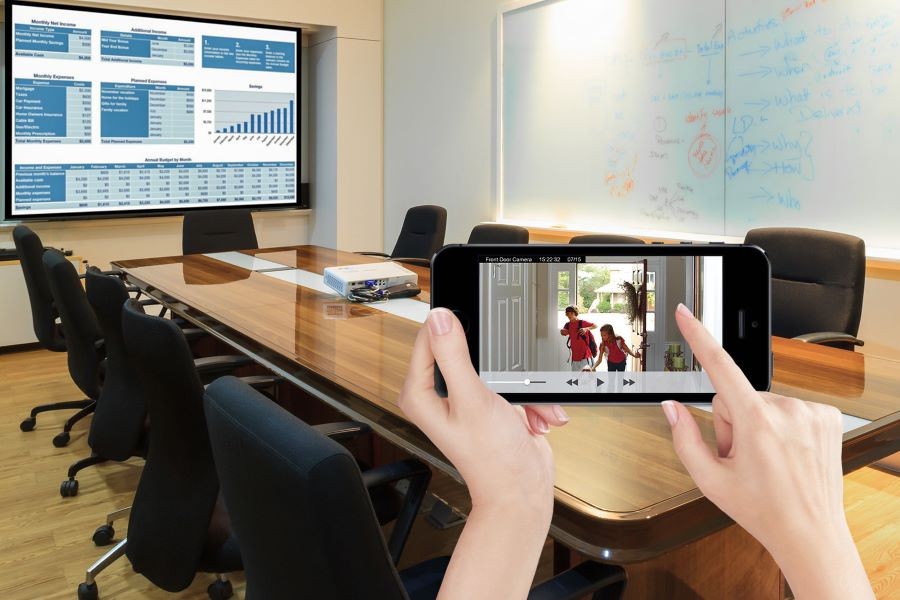  A person at work seeing their children arrive home on their smartphone through their front door security camera. 