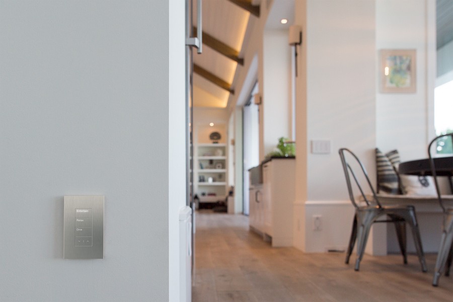 a room with chairs, white walls, and Lutron lighting control buttons on the wall