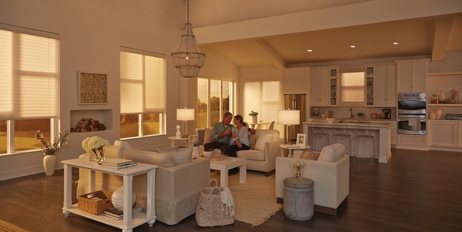 A couple sitting in a living room with dimmed lighting