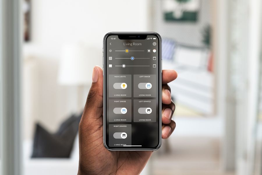 Photo of a hand holding a smartphone up to the camera, the Josh AI lighting control operations on the screen. 