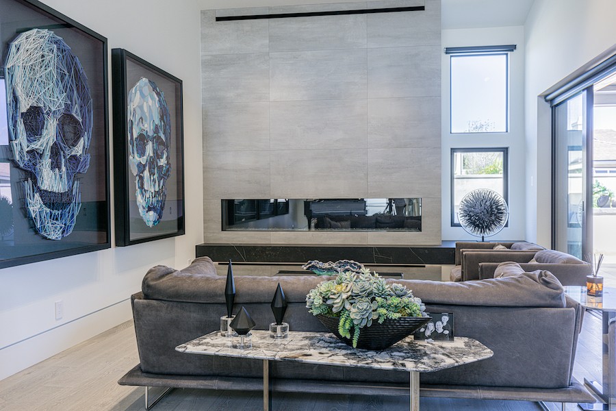 modern living room with automated Lutron shades and two large pieces of artwork depicting skulls