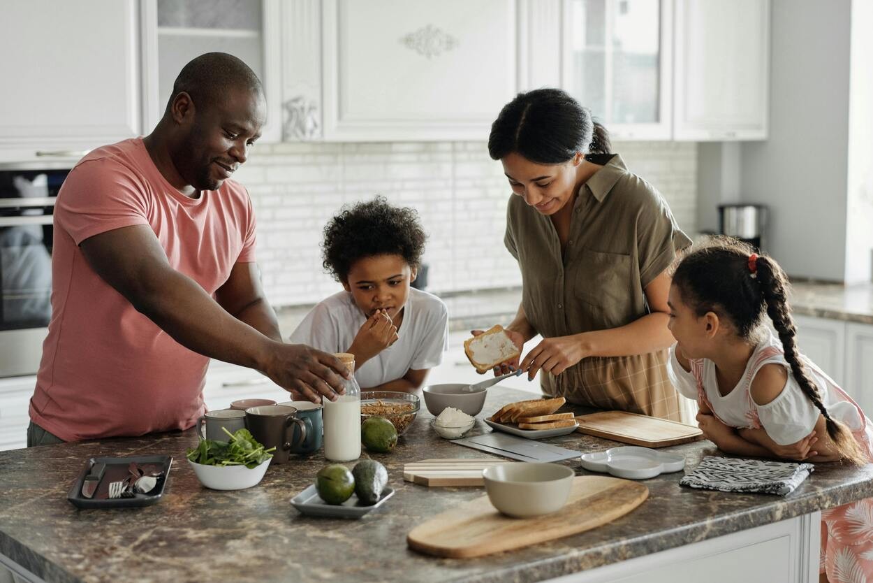 Family making breakfast at their kitchen island, plenty of natural light streaming in. 